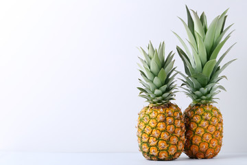 Ripe pineapples on grey background