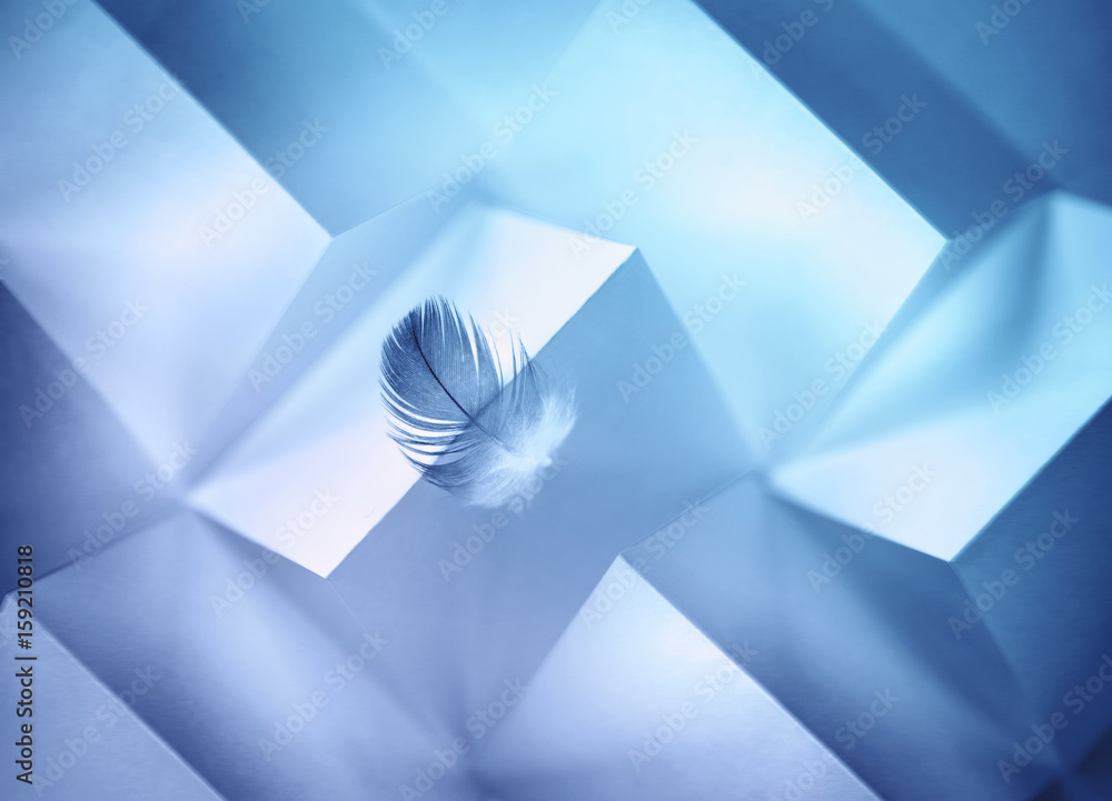 Aufkleber Abstract geometric blue background with triangles and rectangles of paper and a Light air feather in balance on the edge of the paper edge.