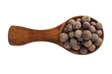Wooden spoon with allspice seeds isolated on a white background