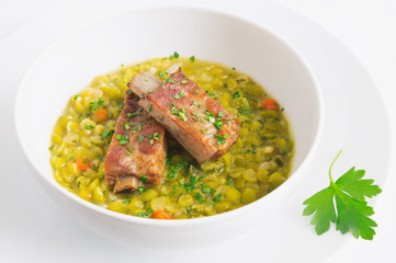 split pea soup with roasted pork ribs decorated with parsley