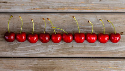 Red ripe organic cherries in row on a wooden background
