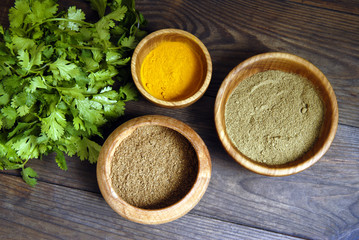 Coriander, saffron and verdure on wood background