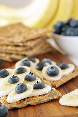 Banana and blueberries on pumpkin seeded crackers - shallow dof