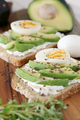 Avocado, cream cheese and boiled eggs on wholemeal bread - shallow dof