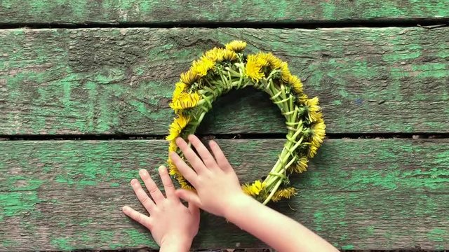 child with a wreath from dandelions