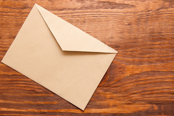 Blank brown envelope on wooden background top view. Office supplies, news, new message concept