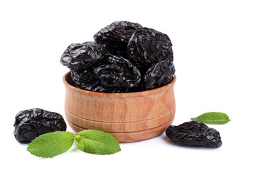 Dried plums - prunes in wooden bowl isolated on white background