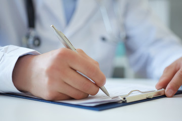 Male medicine doctor hand holding silver pen writing something on clipboard closeup. Ward round, patient visit check, medical calculation and statistics concept. Physician ready to examine patient - obrazy, fototapety, plakaty
