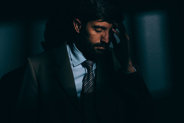 Businessman or political prisoner in dark cell. Concept of white collar crime