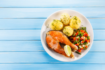 Grilled salmon with potatoes on wooden table