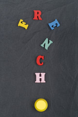 FRENCH word on black board background composed from colorful abc alphabet block wooden letters, copy space for ad text. Learning english concept.