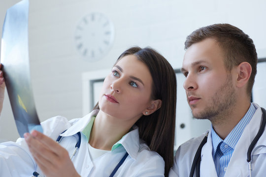 Male and female doctors discussing x-ray image.