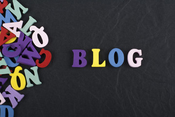 BLOG word on black board background composed from colorful abc alphabet block wooden letters, copy space for ad text. Learning english concept.