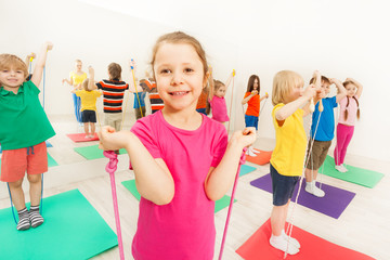 Happy kids having fun with jumping ropes in gym