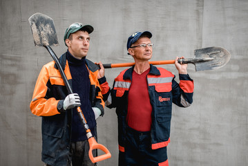 business, building, teamwork and people concept - group of smiling builders outdoors