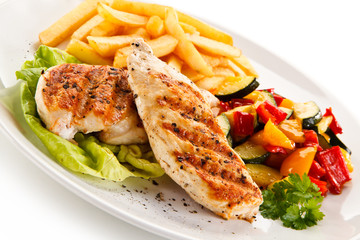 Grilled chicken fillet with french fries on white background