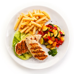 Grilled chicken fillet with french fries on white background