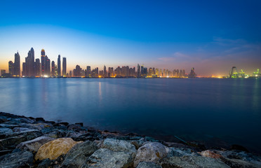 The beauty panorama of skyscrapers in Dubai from promenade at dusk.