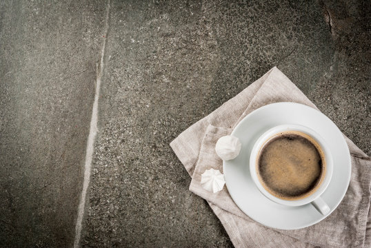 Coffee break. Breakfast. Morning. Coffee cup and two meringues on a stone dark table. Top view copy space