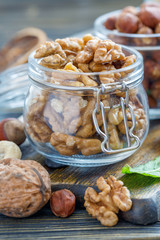 Walnuts and hazelnuts in glass jars.
