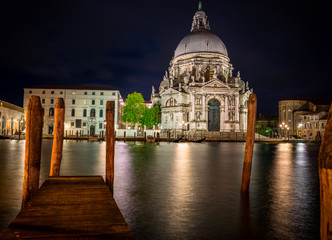 Fototapeta na wymiar Ornate facade of the Santa Maria della Salute Church, Venice, illuminated at night, built by the Ventians to offer thanks for surviving the Plague