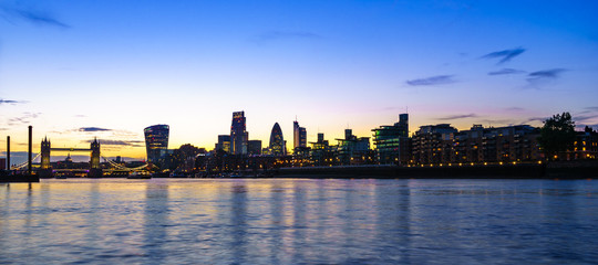 Fototapeta premium London skyline at dusk including Tower Bridge and skyscrapers at financial district