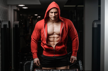 Fototapeta na wymiar Strong Athletic Man Fitness Model in a hood Torso showing six pack abs