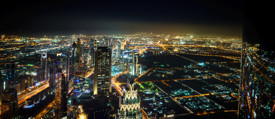 Fototapeta na wymiar Dubai Downtown Night Panorama From Top with blurry reflection on the right site.UAE