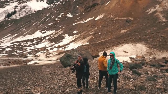 the group of travelers in the mountains waving to the camera