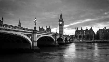 Fototapeta na wymiar Big Ben and Westminster bridge in London at dusk. Black and white photo with dramatic sky