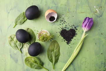 Flower of tulip with black eggs and sesame heart shaped on the green background. Concept of healthy eating.