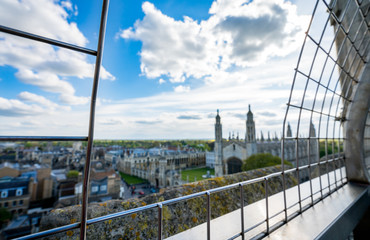 Blurry panorama of the city Cambridge from the observation tower of St.Mary's church. Picture took through bars.