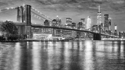 Fototapeta na wymiar Black and white photo of Brooklyn Bridge and Manhattan at night, New York City, USA.