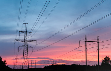 high-voltage power lines at sunset. electricity distribution station.