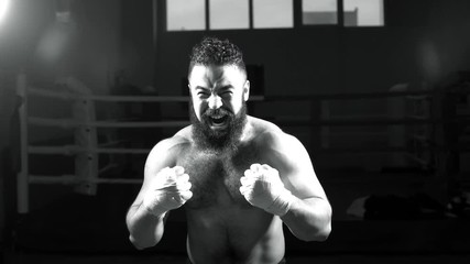 Portrait of a young boxer male in the ring. Athlete fulfills blows