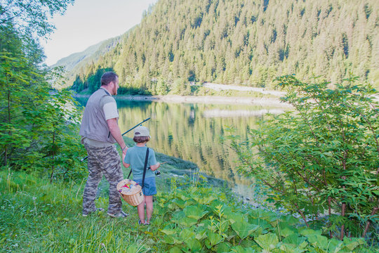 Pap&agrave; e figlia stanno andando a pescare insieme in un lago in montagna