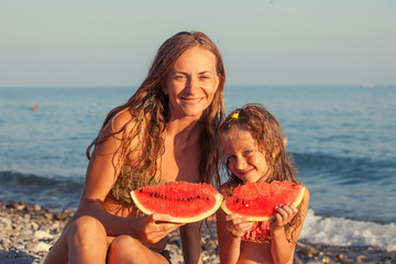 Child with mother eating watermelon