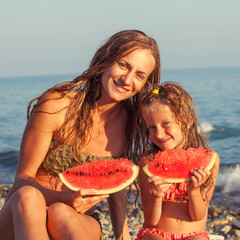 Child with mother eating watermelon