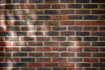 Background of red brick wall pattern with tree shadows