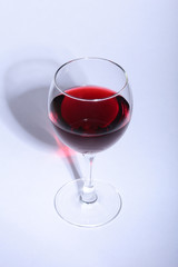Glass with red wine grapes isolated on white background.
