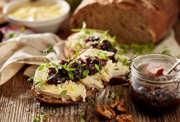 Sandwiches with rustic  bread with goat cheese, caramelized red onion and fresh thyme on wooden table