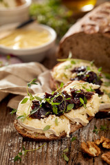Sandwiches with rustic  bread with goat cheese, caramelized red onion and fresh thyme on wooden table