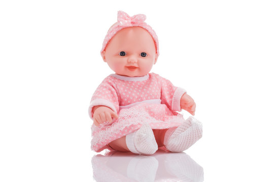 Cute little plastic baby doll with blue eyes sitting  isolated on white background