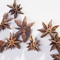 Star shaped anise seeds on a white wooden background