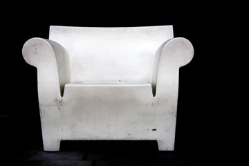 Dirty white chair against black background.