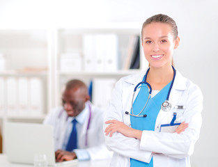 A smiling female doctor with a folder in uniform indoors