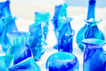 Blue glassware on a background of white stucco walls, close-up