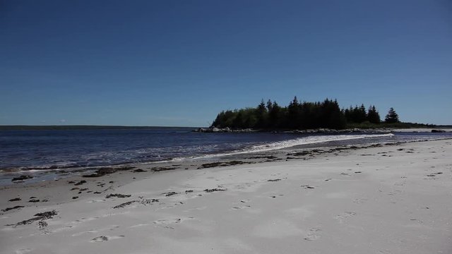 view of a white sandy beach with ocean in nova scotia 