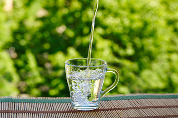 The water is poured into a glass cup