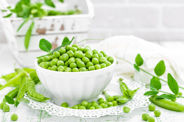 Green peas with leaves on white background